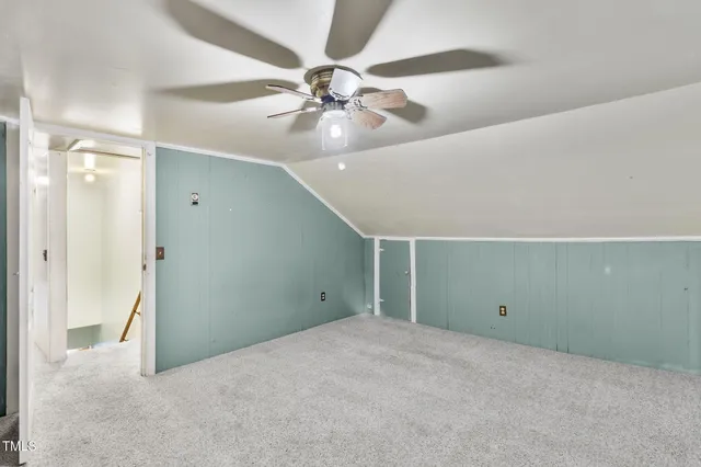 an empty room with closet and fan