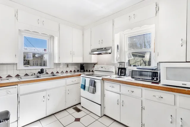 a kitchen with cabinets stainless steel appliances a sink and a window