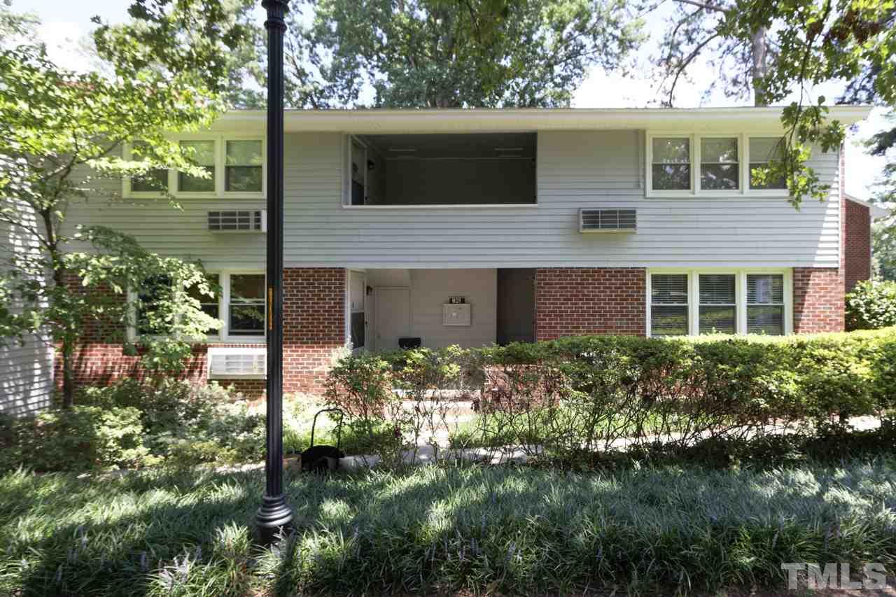 a view of house with a yard and potted plants
