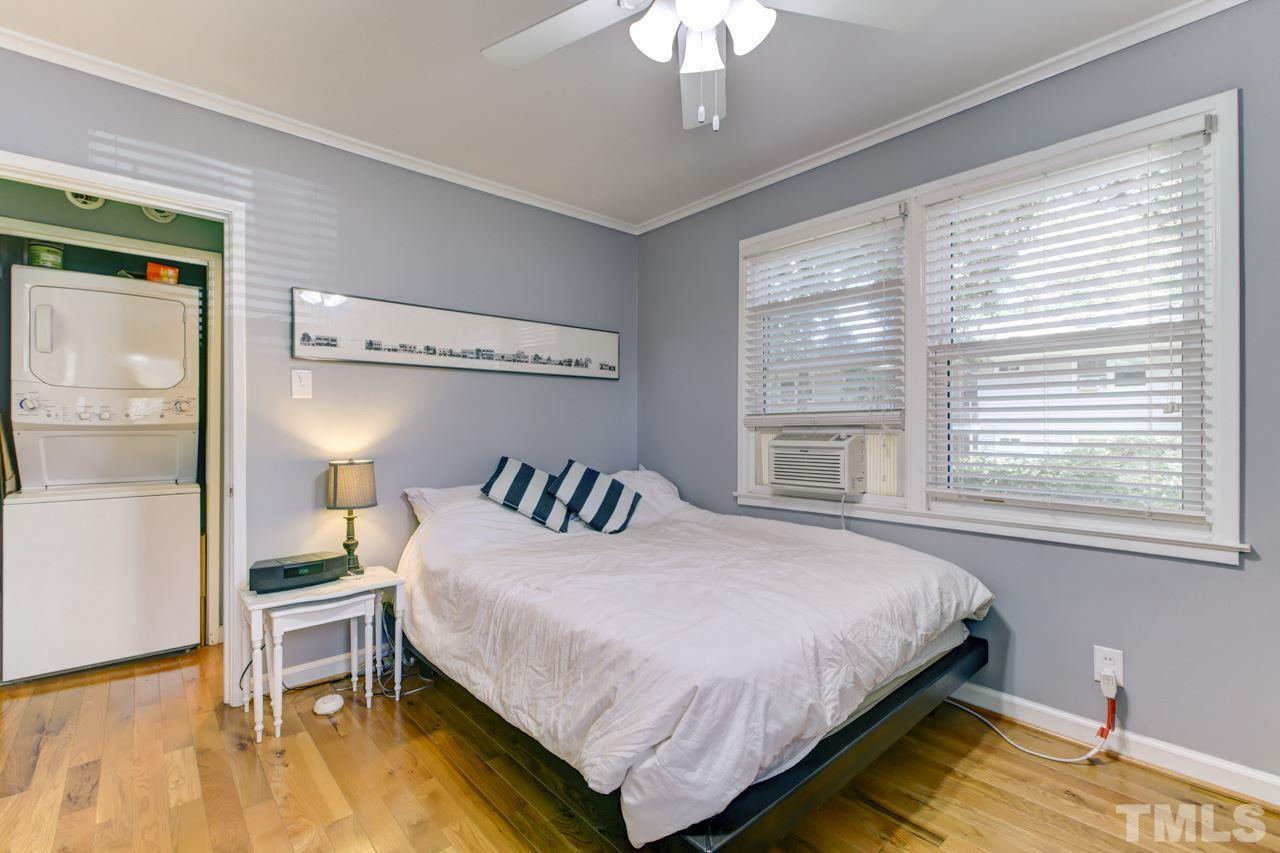 821 Daniels Street, Unit B Raleigh, NC 27605 - Photo 15 of 25 a bedroom with a bed and a chandelier