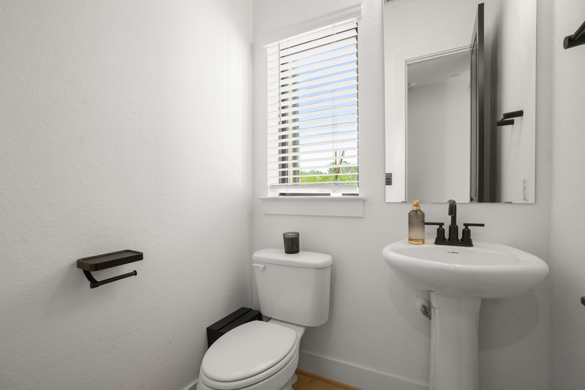154 LITTLE Strm Cove Austin, TX 78737 - Photo 27 of 37 A crisp white powder room includes a classic pedestal sink under a tall mirror.