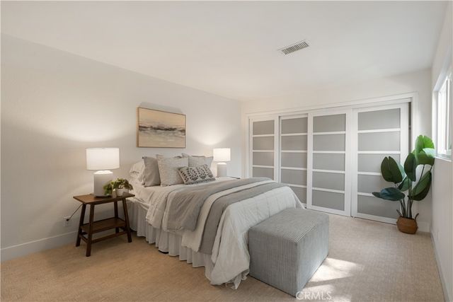 a bedroom with a bed and a potted plant