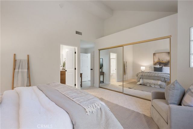 a spacious bedroom with a bed and a large mirror