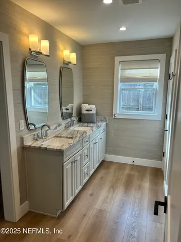 a bathroom with a double vanity sink and a mirror