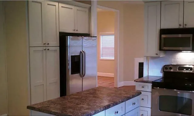 a kitchen with stainless steel appliances granite countertop a refrigerator stove and microwave