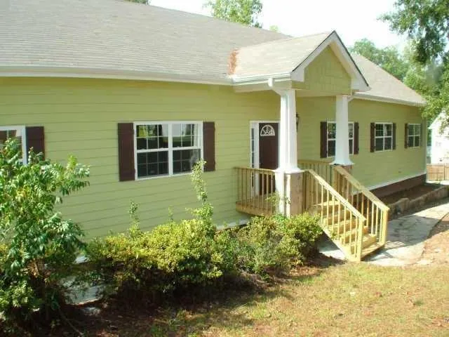a front view of a house with a yard and potted plants