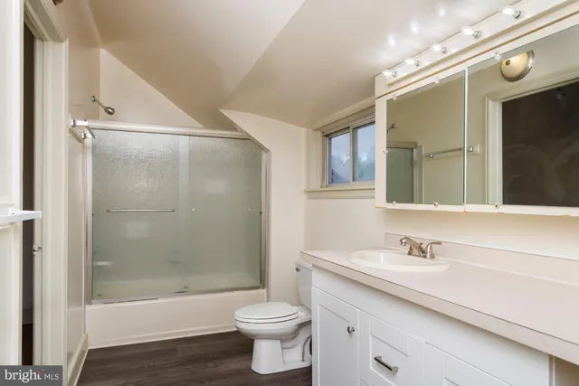 a bathroom with a bathtub shower sink vanity and toilet