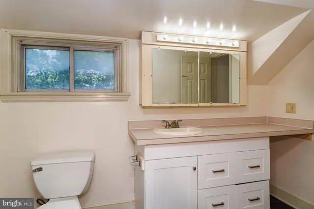 a bathroom with a toilet sink and mirror