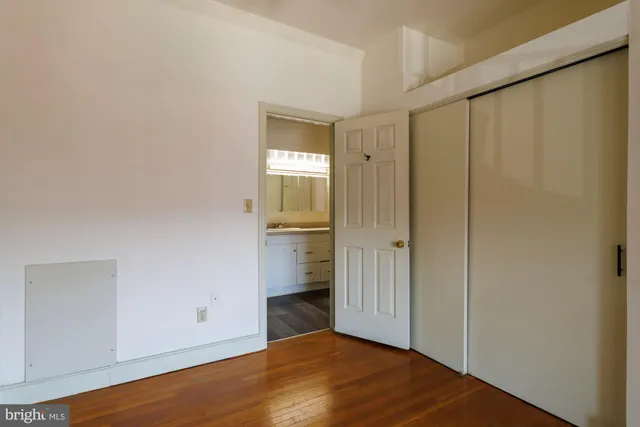a view of empty room with wooden floor and cabinet