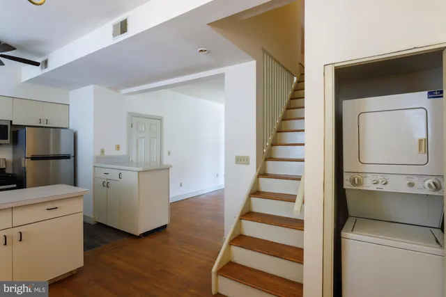a view of a kitchen with white cabinets and wooden floor