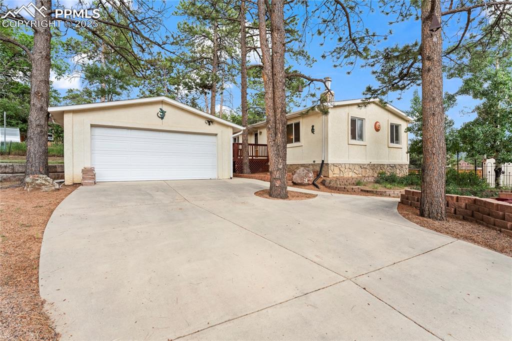 8025 Topeka Avenue Cascade, CO 80809 - Photo 14 of 42 a view of a white house with a large tree and a yard