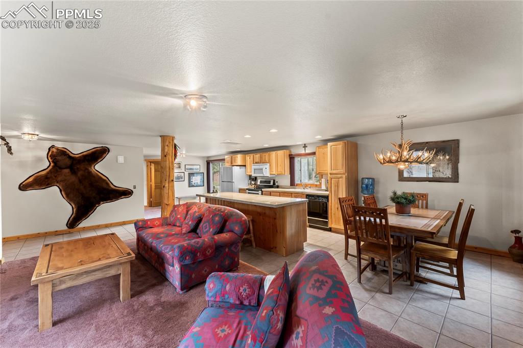 8025 Topeka Avenue Cascade, CO 80809 - Photo 19 of 42 a living room with furniture a rug and a chandelier