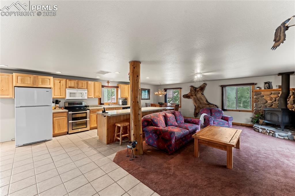 8025 Topeka Avenue Cascade, CO 80809 - Photo 20 of 42 a living room with furniture a fireplace and kitchen view