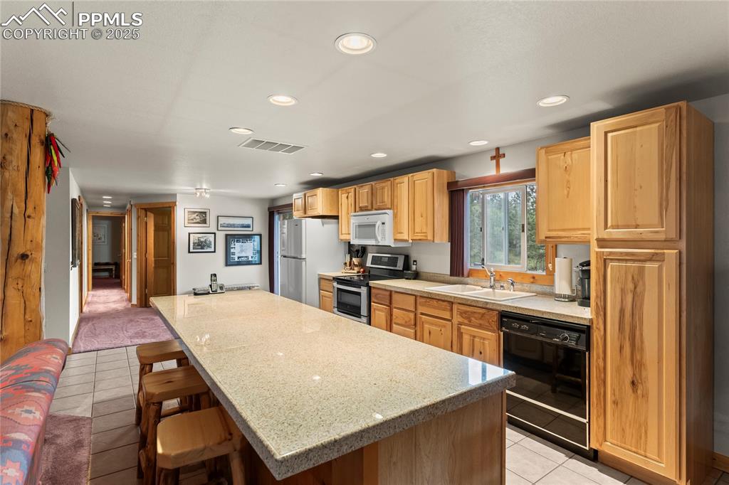 8025 Topeka Avenue Cascade, CO 80809 - Photo 21 of 42 a kitchen with stainless steel appliances granite countertop a stove refrigerator sink and cabinets