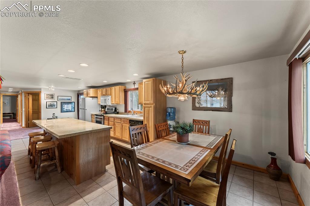 8025 Topeka Avenue Cascade, CO 80809 - Photo 23 of 42 a dining room with a table chairs and a kitchen