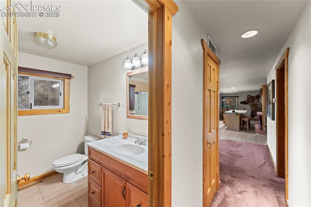 8025 Topeka Avenue Cascade, CO 80809 - Photo 28 of 42 a bathroom with a granite countertop sink mirror vanity and toilet