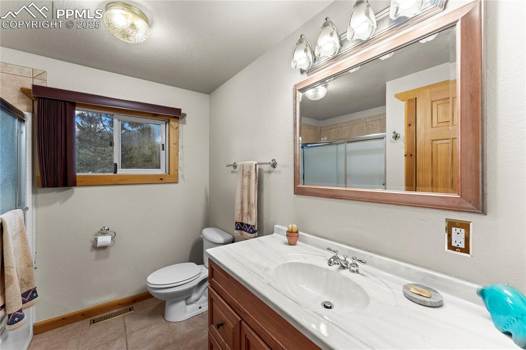 8025 Topeka Avenue Cascade, CO 80809 - Photo 29 of 42 a bathroom with a sink a toilet and mirror