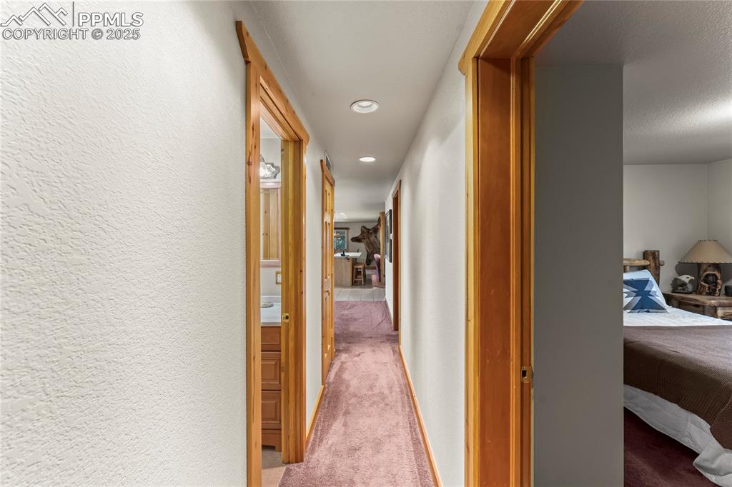 8025 Topeka Avenue Cascade, CO 80809 - Photo 32 of 42 a view of a hallway with wooden floor and a bedroom