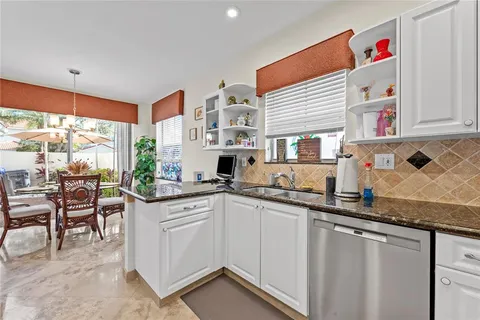a kitchen with granite countertop a sink and cabinets