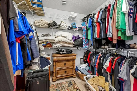 a view of walk in closet with clothes and shoes