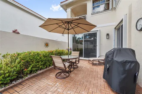 a view of a patio with table and chairs under an umbrella
