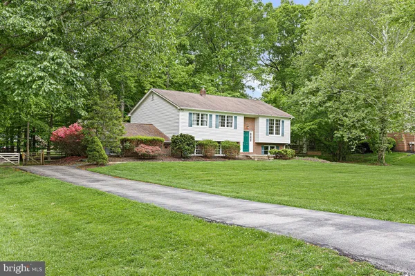 a front view of a house with a yard and trees