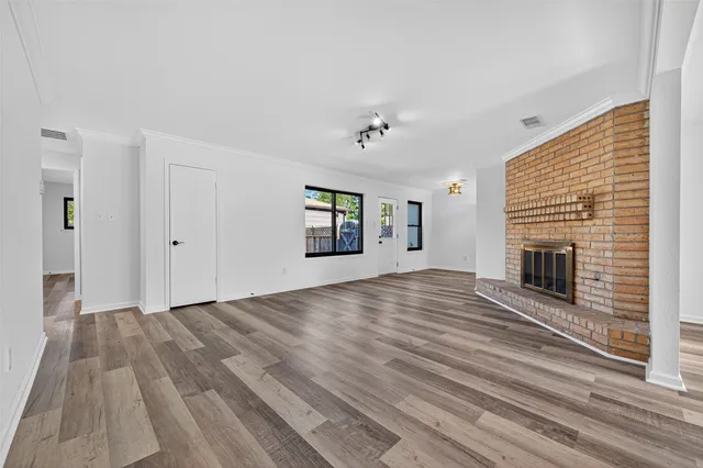 a view of empty room with wooden floor and fireplace