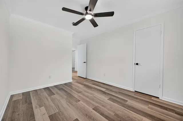 a view of empty room with wooden floor