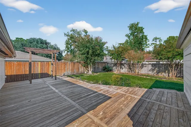 a view of backyard with wooden fence and potted plants