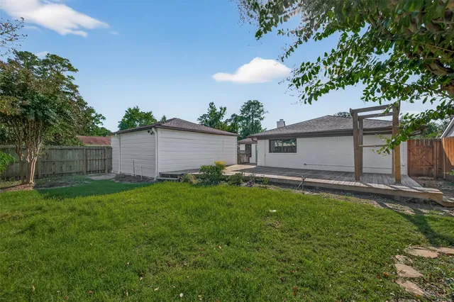 a view of a backyard with table and chairs and a large tree