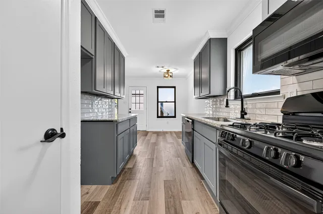 a kitchen with stainless steel appliances granite countertop a stove and a refrigerator