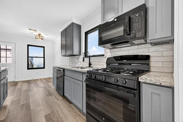 a kitchen with stainless steel appliances granite countertop a stove microwave and sink