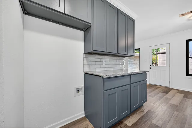 a kitchen with granite countertop cabinets and wooden floor