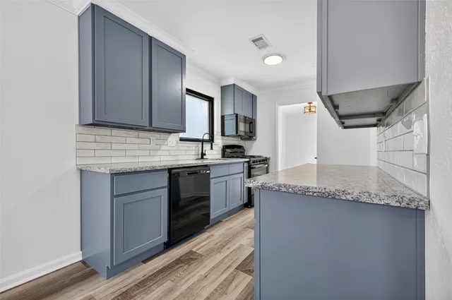 a kitchen with granite countertop cabinets stainless steel appliances and a counter space