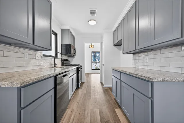 a kitchen with granite countertop stainless steel appliances and wooden cabinets