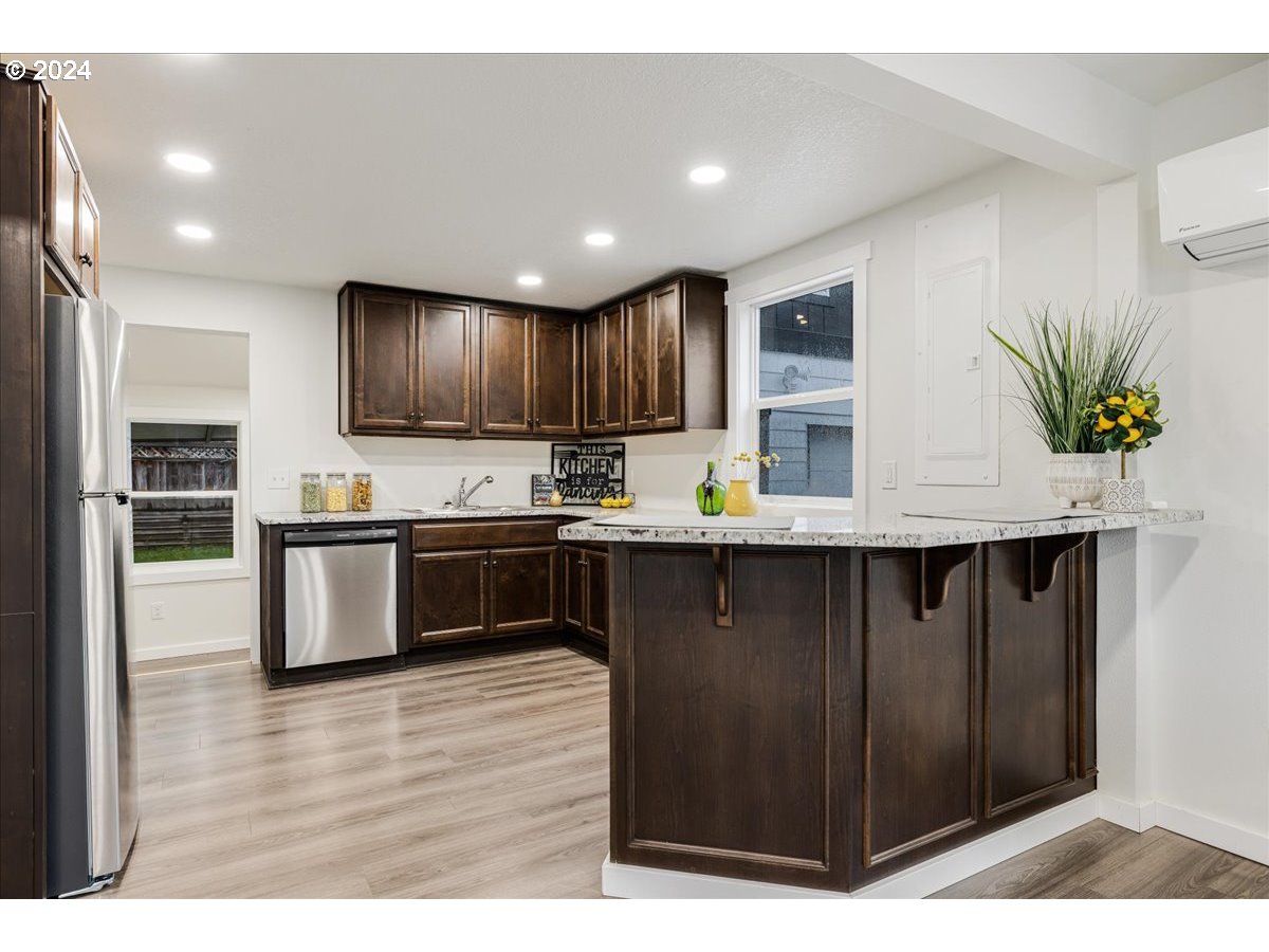 711 Southeast 5th Street Gresham, OR 97080 - Photo 16 of 44 a kitchen with kitchen island granite countertop wooden cabinets a refrigerator and a stove