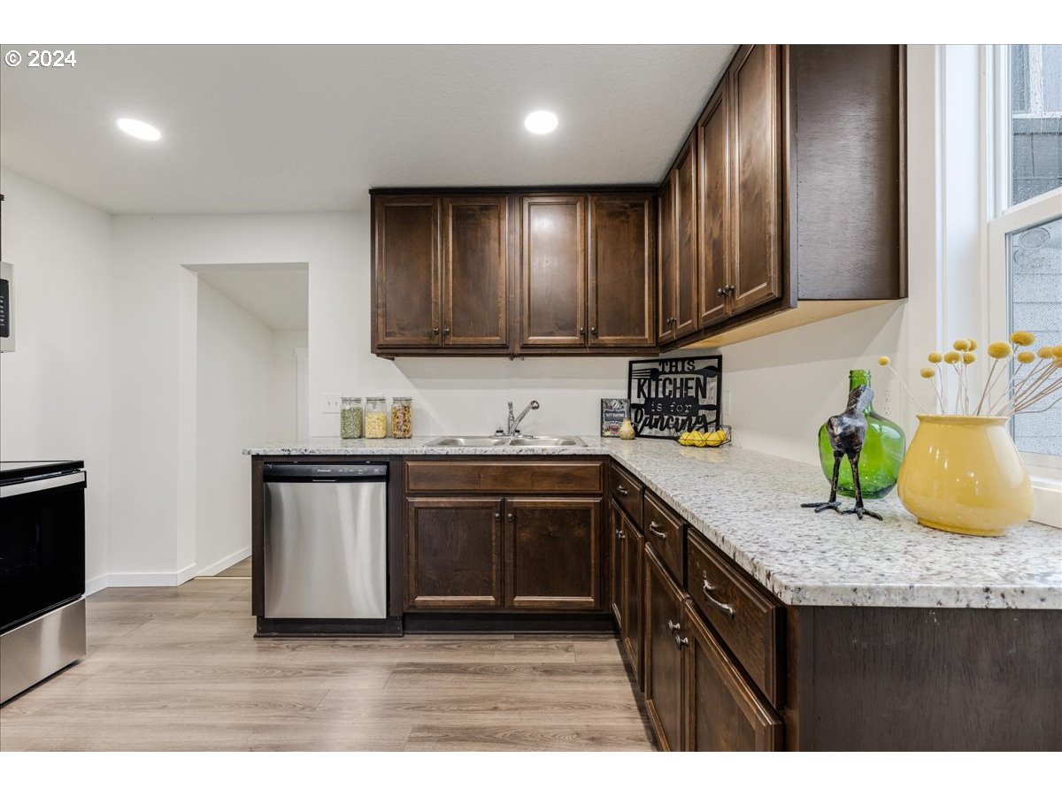 711 Southeast 5th Street Gresham, OR 97080 - Photo 17 of 44 a kitchen with granite countertop cabinets stainless steel appliances and a sink