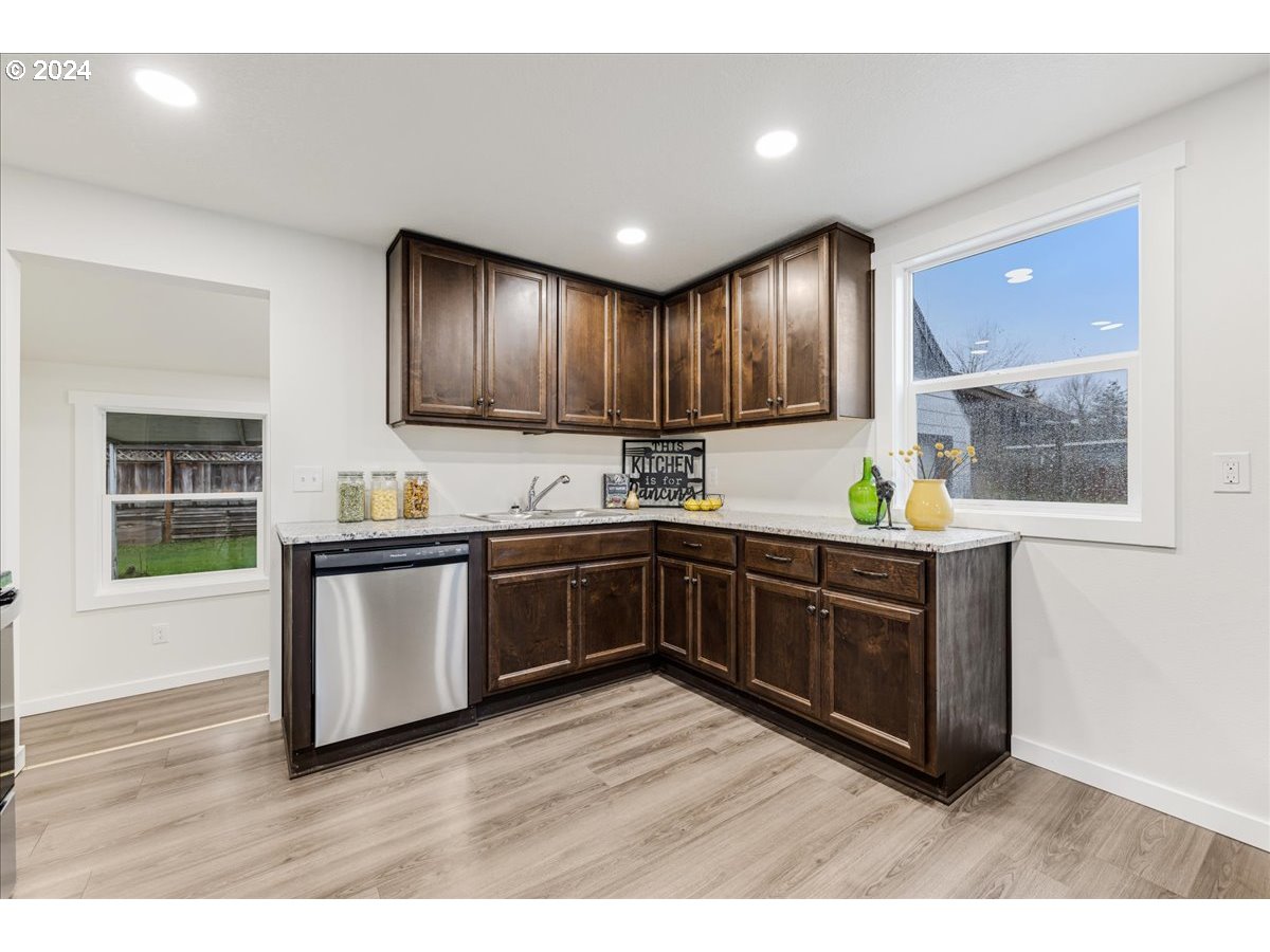 711 Southeast 5th Street Gresham, OR 97080 - Photo 18 of 44 a kitchen with granite countertop wooden cabinets and white appliances