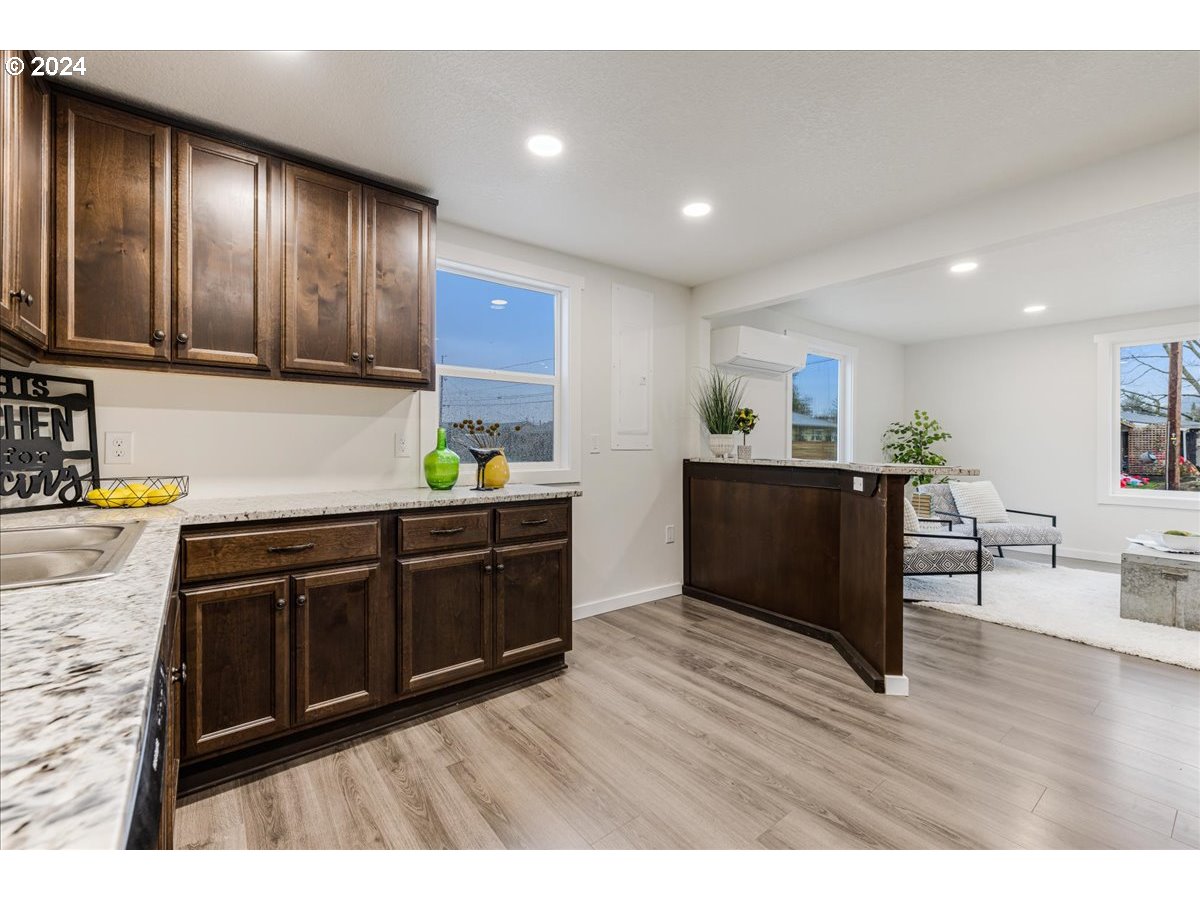 711 Southeast 5th Street Gresham, OR 97080 - Photo 19 of 44 a kitchen with stainless steel appliances granite countertop a refrigerator a sink dishwasher and wooden cabinets with wooden floor