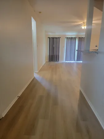 a view of an empty room with wooden floor