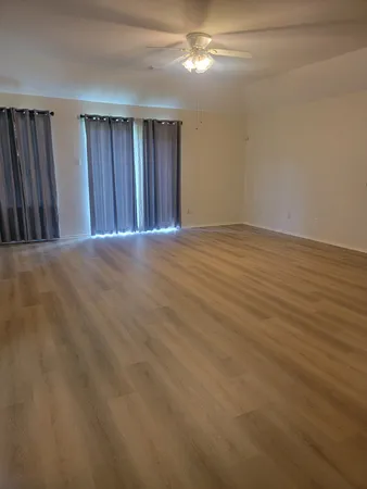 a view of an empty room with wooden floor