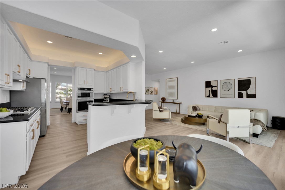 8981 Rivers Edge Drive Las Vegas, NV 89117 - Photo 17 of 69 An open-concept design seamlessly connects the kitchen and living areas, offering functional flow for modern living.