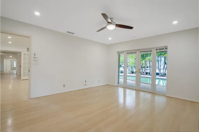 an empty room with ceiling fan and window