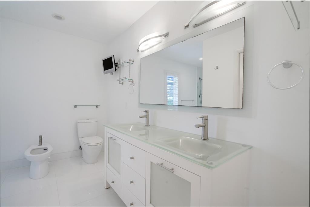 3721 Northeast 29th Avenue Lighthouse Point, FL 33064 - Photo 15 of 43 a bathroom with a toilet sink and mirror