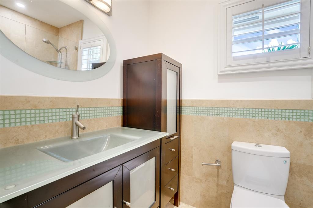 3721 Northeast 29th Avenue Lighthouse Point, FL 33064 - Photo 26 of 43 a bathroom with a sink a mirror and a toilet