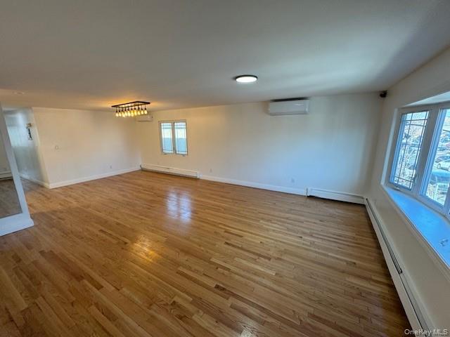 103-14 169th Street Queens, NY 11433 - Photo 3 of 18 an empty room with wooden floor and windows