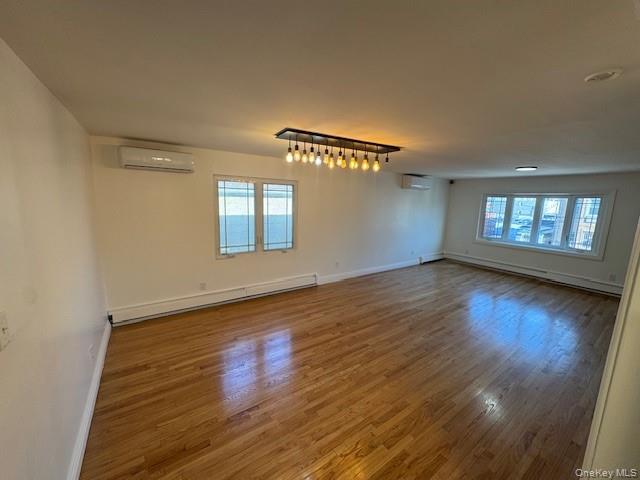 103-14 169th Street Queens, NY 11433 - Photo 5 of 18 an empty room with wooden floor and windows