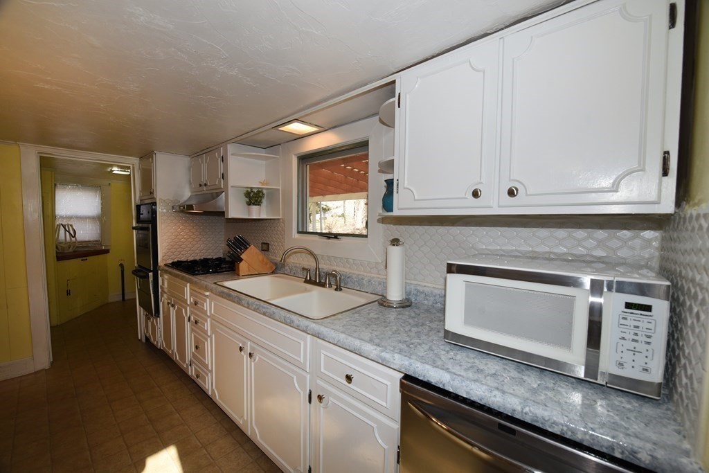 7 Summer Street Kingston, MA 02364 - Photo 17 of 41 a kitchen with granite countertop white cabinets and white appliances
