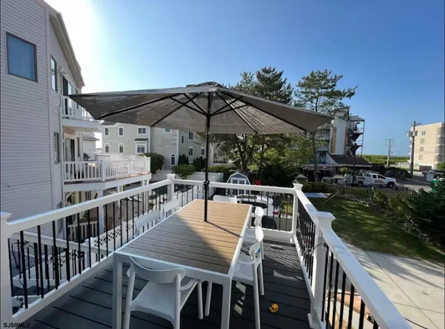 a roof deck with table and chairs with wooden floor