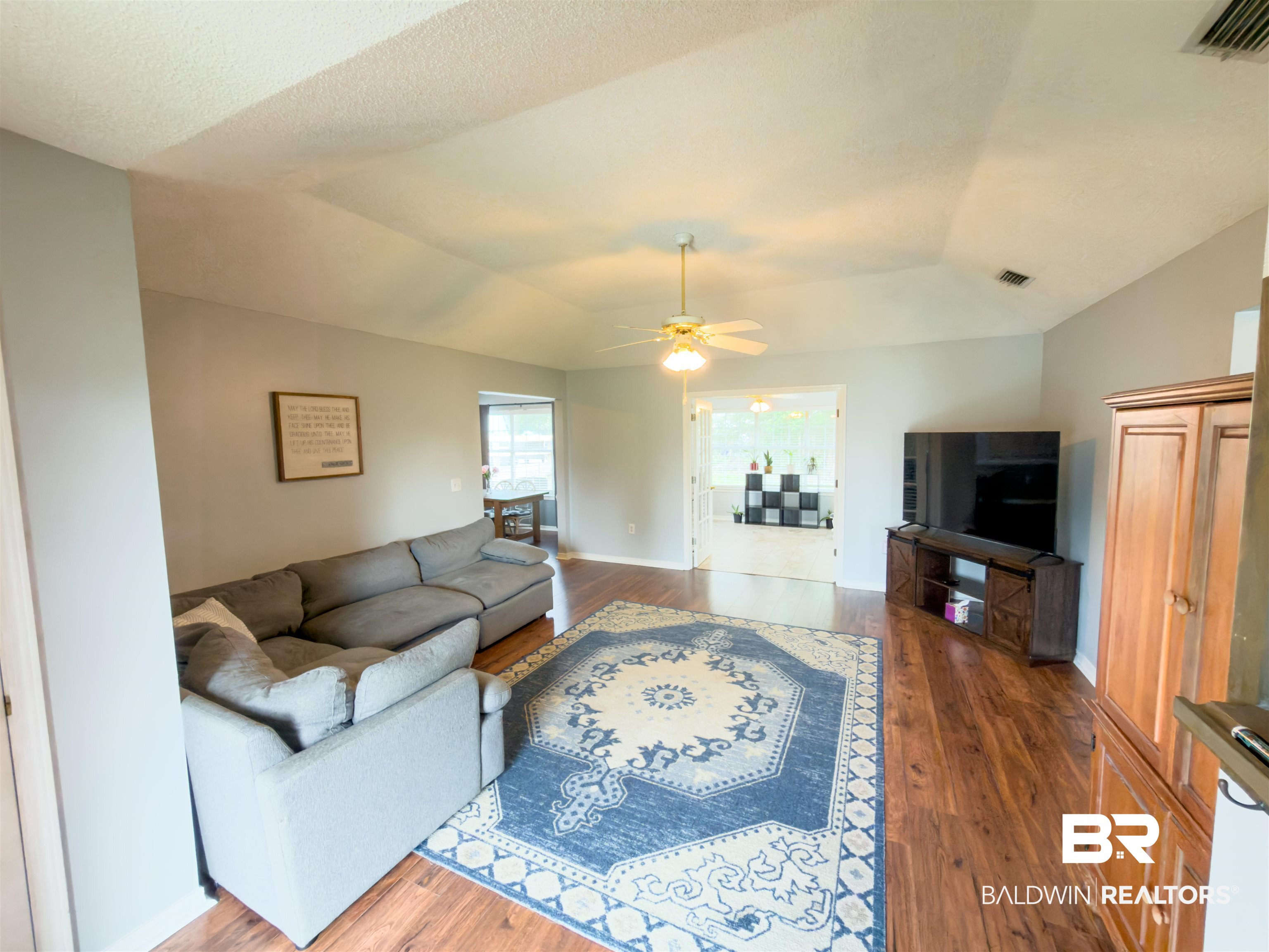 129 Pennbrooke Loop Foley, AL 36535 - Photo 4 of 44 Living area featuring dark wood finished floors, a ceiling fan, and vaulted ceiling